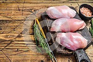 Boneless Raw Chicken thigh fillet. Wooden background. Top view. Copy space