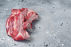 Boneless Raw lamb neck meat on a butcher table. Gray background. Top view. Copy space