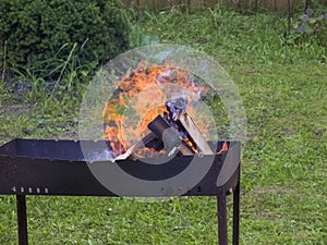 Bonfire, campfire, pyre in the day time. Round logs burning. The production of charcoal for the barbecue