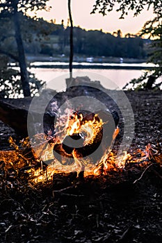 Bonfire in the campsite near the lake during sunset