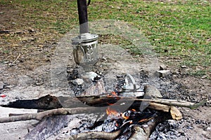 Bonfire, iron metal travel kettle, samovar and hot coals