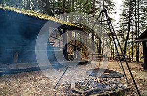 Bonfire at a rural farm setting in a middle of a forest against abandoned hut or barn