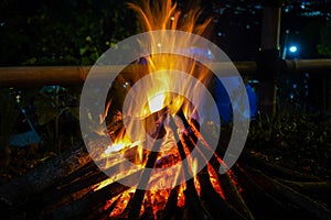 bonfire and some sparks on the camping ground, with citylight in the background