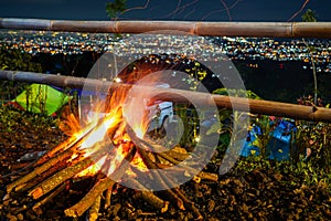 bonfire and some sparks on the camping ground, with citylight in the background