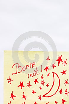 Bonne nuit good night handwriting text close up isolated on yellow paper with copy space