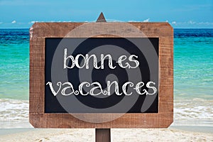 Bonnes vacances (meaning happy holiday) written on a wooden vintag chalk board photo