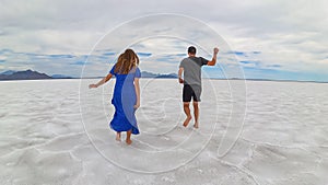 Bonneville - Rear view of couple holding hands standing on Bonneville Salt Flats in Wendover, Western Utah, USA