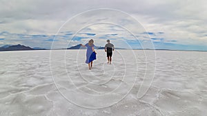 Bonneville - Rear view of couple holding hands standing on Bonneville Salt Flats in Wendover, Western Utah, USA