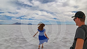 Bonneville - Rear view of couple holding hands standing on Bonneville Salt Flats in Wendover, Western Utah, USA