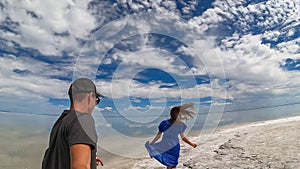 Bonneville - Rear view of couple holding hands standing on Bonneville Salt Flats in Wendover, Western Utah, USA