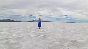 Bonneville - Rear view of woman in blue dress running on Bonneville Salt Flats near Wendover, Western Utah, USA