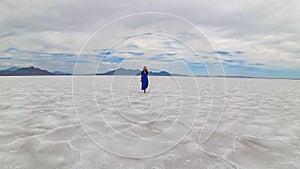 Bonneville - Rear view of woman in blue dress running on Bonneville Salt Flats near Wendover, Western Utah, USA