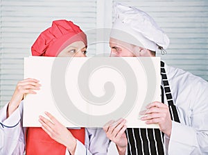 Book accounting in restaurant. Chef and prep cook holding empty account sheet. Master cook and helper performing book