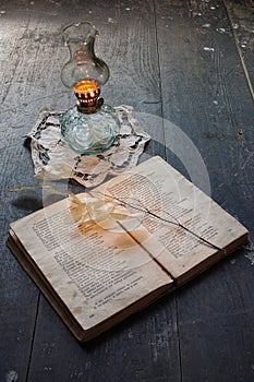 Book and ancient oil lamp photo