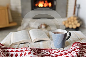 Book and cup of tea near fireplace