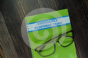 The Book of Emergency Response Team isolated on wooden table