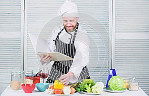 Book family recipes. Ultimate cooking guide for beginners. According to recipe. Man bearded chef cooking food. Guy read