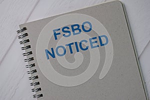 Book about FSBO Noticed isolated on wooden table