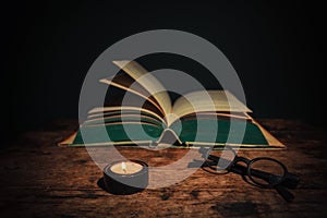 Book and glasses lit by candle