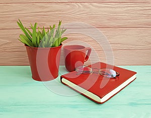 Book glasses pot with grass red cup of coffee vintage on table wooden concept