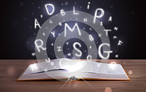 Book with glowing letters flying out on wood deck