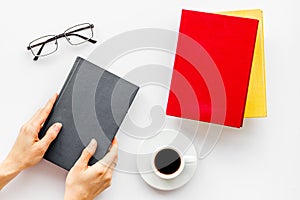 Book in hands for reading and education with coffee and glasses on white background flatlay