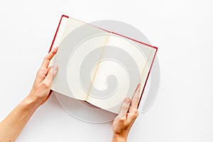Book in hands for reading on white library desk background top view space for text