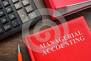 Book with Managerial accounting info, calculator and folder. photo