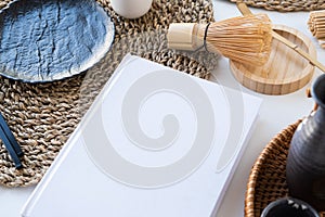 Book mockup design. Blank white book on dining table in asian style with tableware