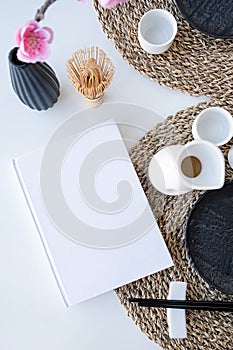 Book mockup design. Blank white book on dining table in asian style with tableware