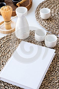 Book mockup design. Blank white book on dining table in asian style with tableware