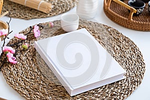 Book mockup design. Blank white book on dining table in asian style with tableware