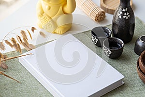 Book mockup design. Blank white book on dining table in asian style with tableware