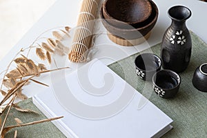Book mockup design. Blank white book on dining table in asian style with tableware