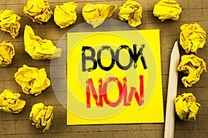 Book Now. Business concept for Reservation Buy Booking written on sticky note paper on the vintage background. Folded yellow paper