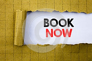 Book Now. Business concept for Reservation Buy Booking written on white paper on the yellow folded paper.