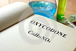 Book with oxycodone and test tubes. photo