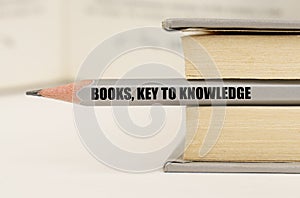 In the book between the pages lies a pencil with the inscription - Books, key to knowledge