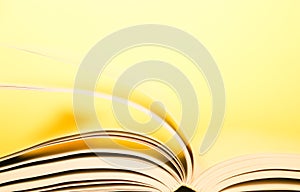 Book pages turning over yellow background. Pages flipping over.