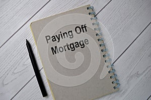 Book about Paying Off Mortgage isolated on wooden table