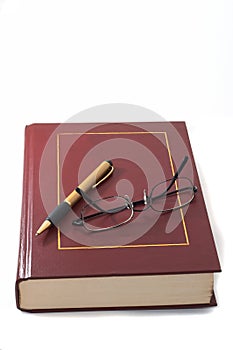 Book with pen and glasses