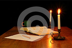 Book, Pencil and Paper Illuminated by Candlelight photo