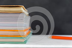 book and pencil on white table black board background with study