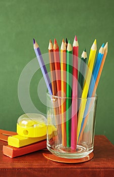 Book pile with apple, globe, pencils and sharpener on the school blackboard. Teacher`s day concept