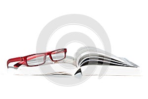 Book and reading glasses on a white background