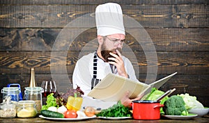 Book recipes. According to recipe. Man bearded chef cooking food. Guy read book recipes. Culinary arts concept. Man