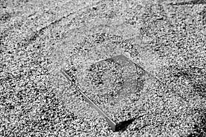 Book on the sand on a blurred background, covered with sand, black and white, monochrome.