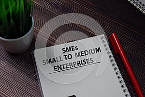 Book about SMEs - Small To Medium Enterprises isolated on wooden table