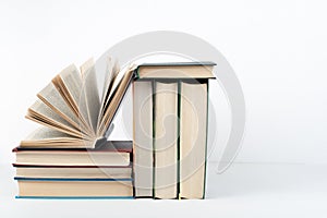 Book stack, hardback colorful books on wooden table, white background. Back to school. Copy space for text. Education