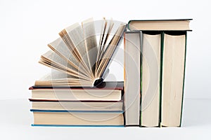 Book stack, hardback colorful books on wooden table, white background. Back to school. Copy space for text. Education